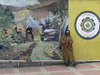 Algeria / Algerie - Bou Saada: playing flute in front of billboard celebrating the Algerian war - photo by J.Kaman