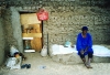 Egypt - Aswan: country life - man by mud brick house (photo by J.Kaman)