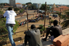 Bissau, Guinea Bissau / Guin Bissau: Amlcar Cabral ave., Empire Square, Carnival, men watching from roof of the Presidential palace - on the right the old Museum, now the PMs office / Avenida Amilcar Cabral, Praa do Imprio, homem a assistir do telhado do palcio da presidncia -  direita o antigo Museu de Bissau, agora a 'Primatura', gabinete do Primeiro Ministro, projecto do Gabinete de Urbanizao Colonial - photo by R.V.Lopes