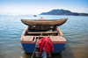 Cape Maclear / Chembe, Malawi: wooden dugout canoe stacked across the gunnels of a fishing boat - Domwe Island in the background - Lake Malawi National Park, UNESCO World Heritage Site, Nankumba Peninsula - photo by M.Torres