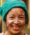 Sankhuwasabha District, Kosi Zone, Nepal: face of a Nepali woman after painting her house - photo by E.Petitalot