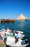 Doha, Qatar: fishermen in the Dhow Harbour with the Museum of Islamic Art as backdrop - photo by M.Torres