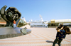 Odessa, Ukraine: woman taking picture of man standing at a statue of a hatching baby, called the 'Golden boy' by sculptor Ernst Neizvestny - Maritime Terminal area - cruise ship Arkona in the dock - photo by K.Gapys