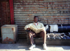 Harlem, New York, USA: man using steet furniture for reading the newspaper - photo by J.Kaman